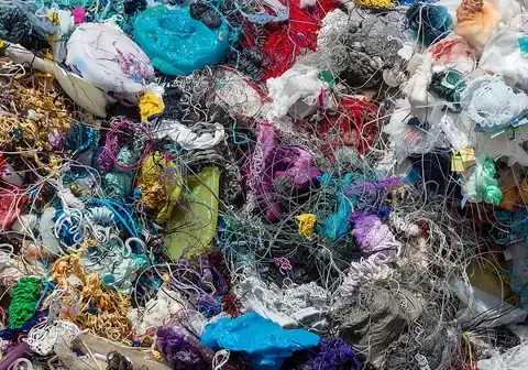 Close-up of shredded, color-sorted plastic waste ready for recycling.