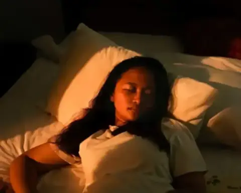 A person lies in bed with warm side lighting, representing nighttime light exposure studied for links to heart structure changes.