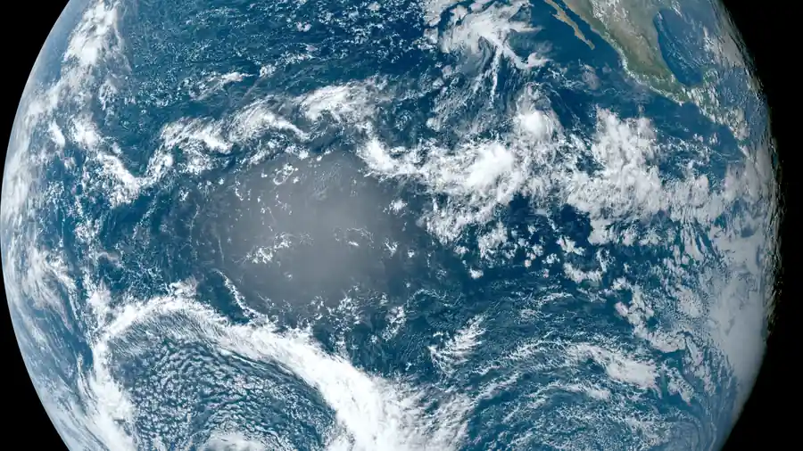 Satellite view of the Pacific Ocean from space with clouds over blue water