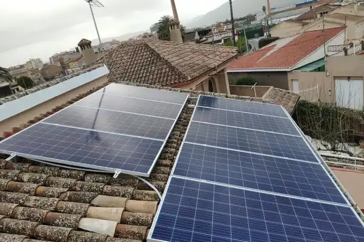 Modern silicon photovoltaic solar panels mounted on a building rooftop angled toward sunlight.