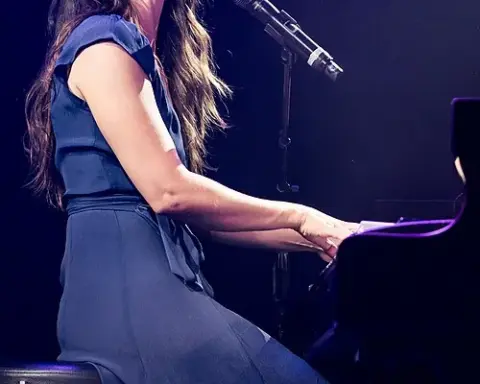 Sara Bareilles performing at a piano during a 2015 concert in Los Angeles