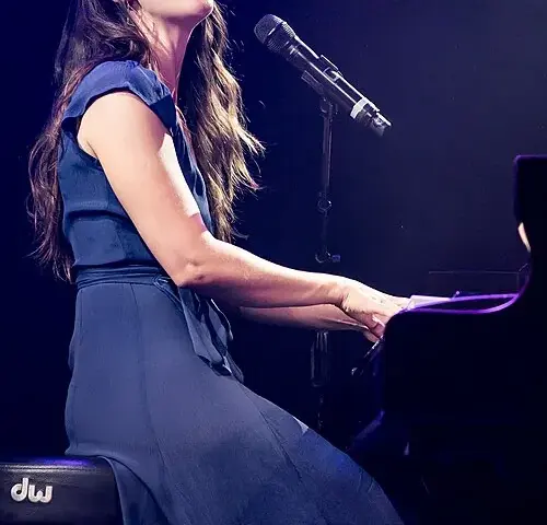 Sara Bareilles performing at a piano during a 2015 concert in Los Angeles