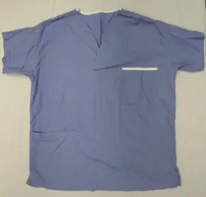 Blue medical scrub top photographed on a plain surface