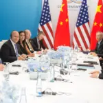 Donald Trump and Xi Jinping seated at a bilateral meeting table during a G20 diplomatic engagement.