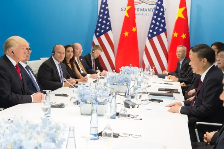 Donald Trump and Xi Jinping seated at a bilateral meeting table during a G20 diplomatic engagement.