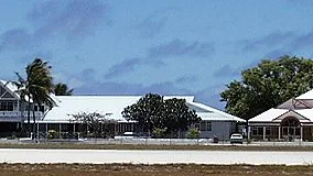 Government and parliament buildings in Yaren, Nauru, seen from across an open road and grounds.