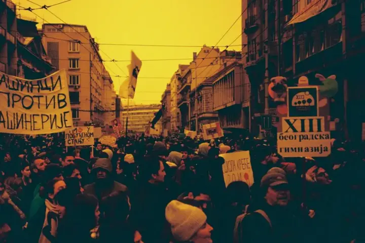 Protesters holding banners in Belgrade during anti-corruption demonstrations