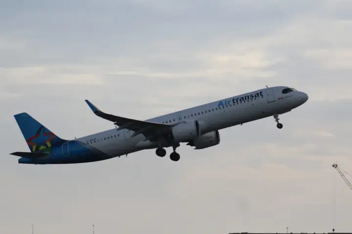Air Transat Airbus A321 single-aisle passenger airplane parked on an airport apron with airline livery visible.
