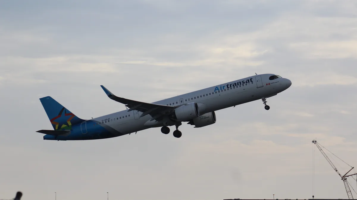 Air Transat Airbus A321 single-aisle passenger airplane parked on an airport apron with airline livery visible.