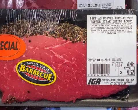 Fresh cuts of uncooked beef and roasts packaged in plastic trays on supermarket shelves under store lighting.