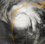Satellite image showing the organized cloud bands and eye region of a powerful hurricane over open ocean.
