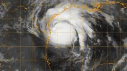 Satellite image showing the organized cloud bands and eye region of a powerful hurricane over open ocean.