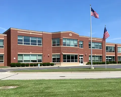 Front entrance and exterior brick facade of a public high school in suburban Michigan under daylight.