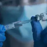 Close-up photograph of a vaccine vial and syringe prepared for an immunization campaign.
