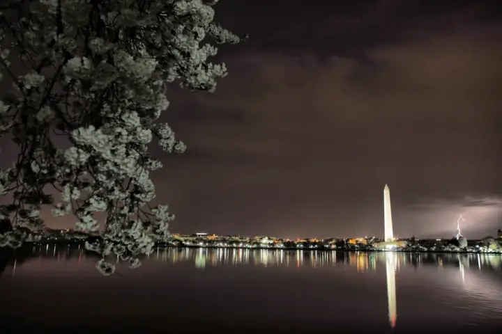 Bolt of lightning illuminating the night sky behind the Washington Monument on the National Mall