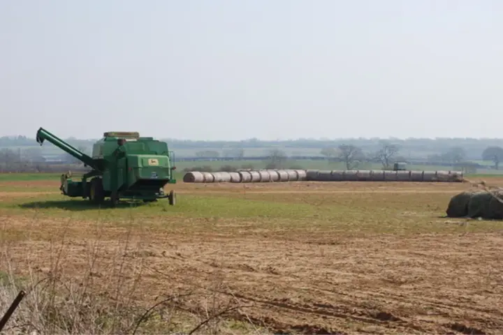 A heavy agricultural combine harvester harvesting grain crops