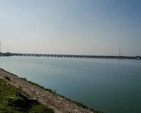 Wide view of the Gandak River basin with flowing water, sediment banks, and distant tree line