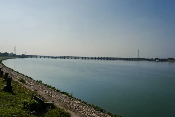 Wide view of the Gandak River basin with flowing water, sediment banks, and distant tree line