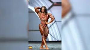 Andrea Shaw posing onstage during an Olympia women’s bodybuilding competition