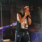 Colombian singer Carlos Vives performing with a harmonica during a Latin music event