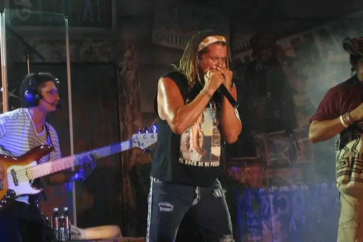 Colombian singer Carlos Vives performing with a harmonica during a Latin music event