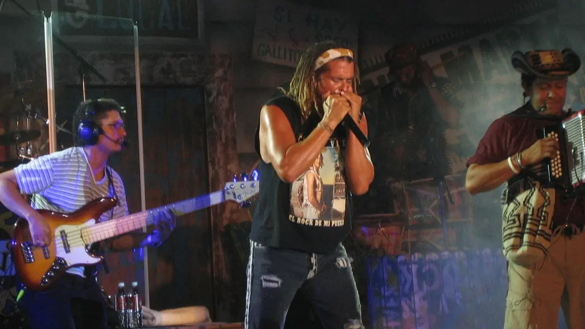 Colombian singer Carlos Vives performing with a harmonica during a Latin music event