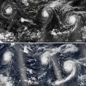 High-resolution satellite view from space showing defined hurricane eye walls and swirling cloud bands over the Pacific Ocean.