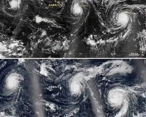 High-resolution satellite view from space showing defined hurricane eye walls and swirling cloud bands over the Pacific Ocean.