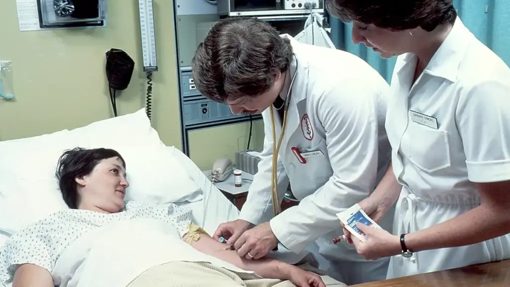 Clinician taking or preparing a blood sample from a patient in a hospital setting