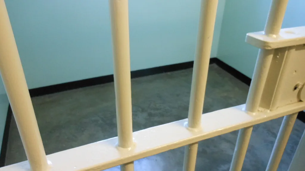 Representative prison bars photograph used as context for federal custody and reentry reporting