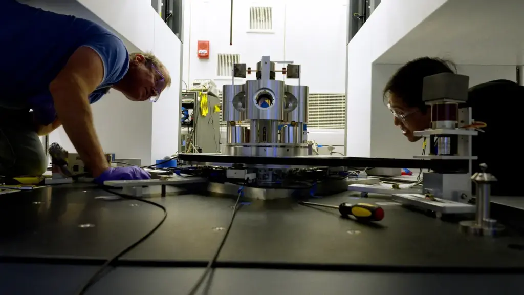 NIST researchers examining a torsion balance used to measure the gravitational constant