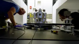 NIST researchers examining a torsion balance used to measure the gravitational constant