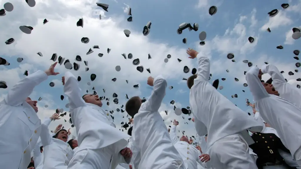 University graduates in academic regalia tossing graduation caps into the air at a commencement ceremony