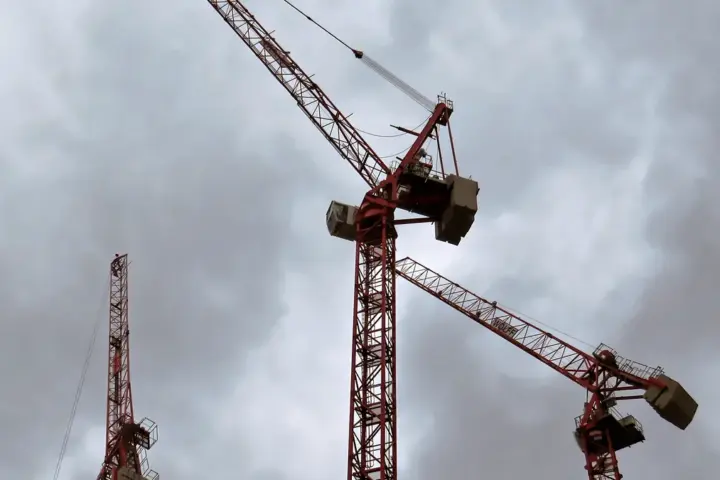 Heavy tower construction cranes operating across a major high-rise residential building site in London