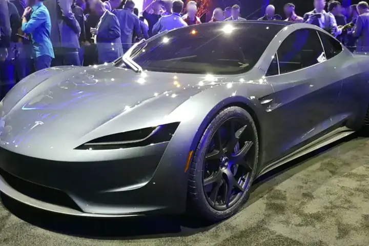 Red second-generation Tesla Roadster prototype vehicle displayed on stage
