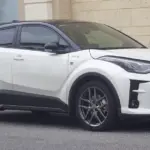 Front view of a dark-toned Toyota C-HR vehicle parked on a paved street