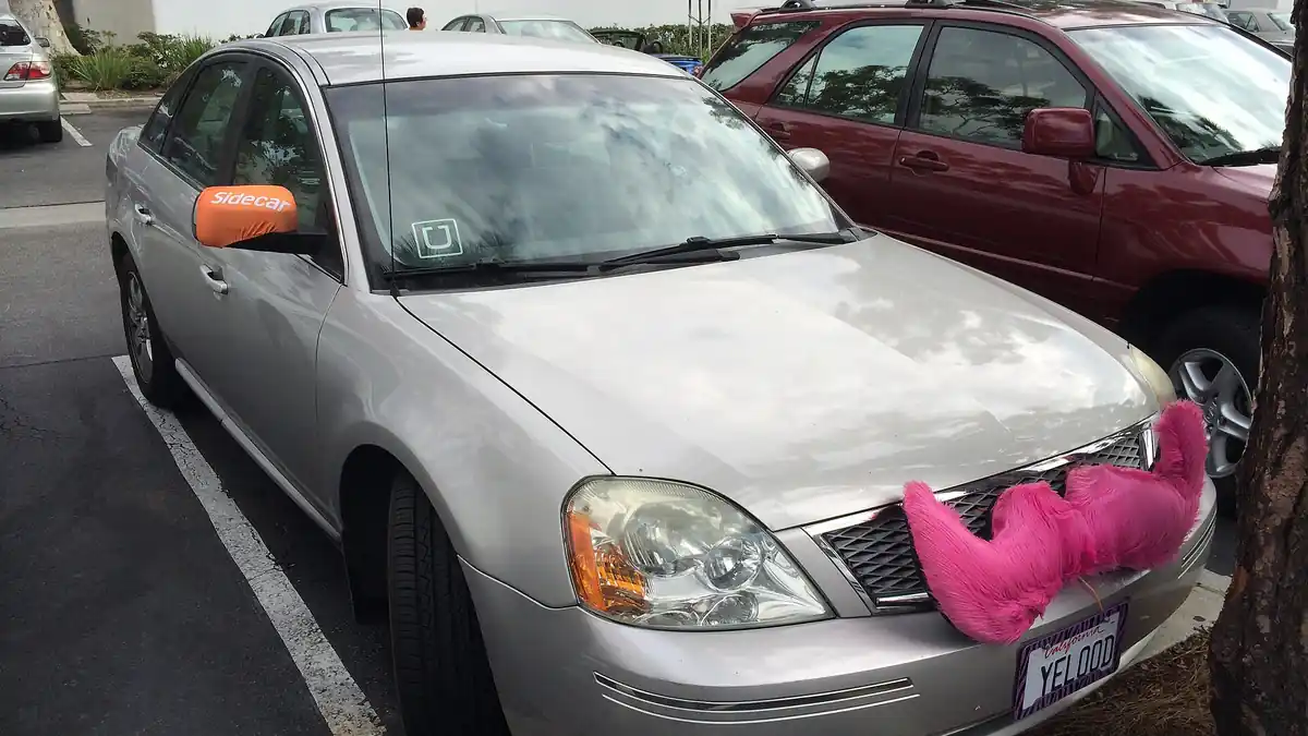 A rideshare vehicle with Uber, Lyft, and Sidecar branding, representing the gig economy transportation services at the center of the $40 million arbitration case.