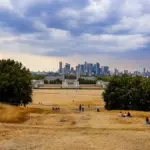 Dry ground and park lawn in Greenwich Park overlooking Canary Wharf in London.