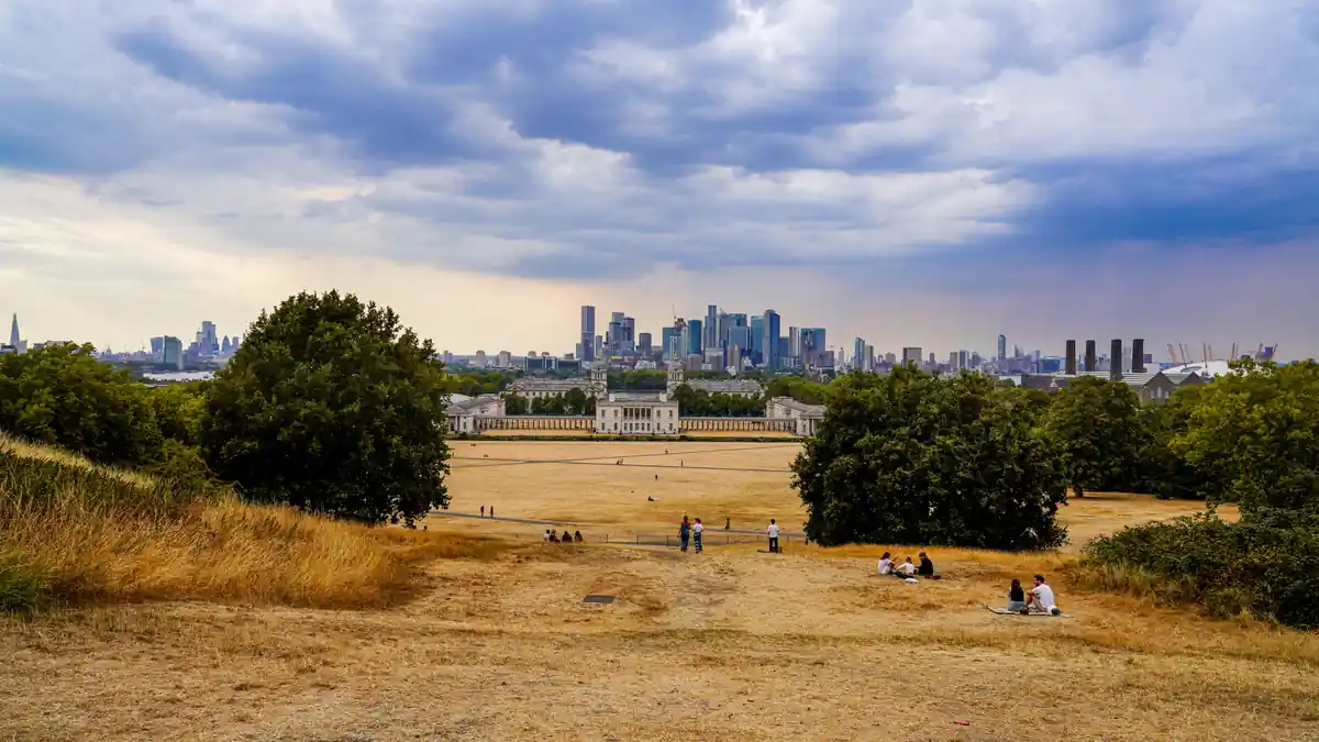 Dry ground and park lawn in Greenwich Park overlooking Canary Wharf in London.