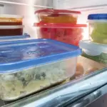 Organized food items and fresh produce stored in clean, transparent containers inside a refrigerator