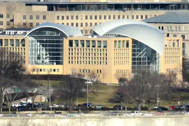 Exterior curved glass and limestone architecture of the United States Institute of Peace headquarters along Constitution Avenue in Washington, D.C.