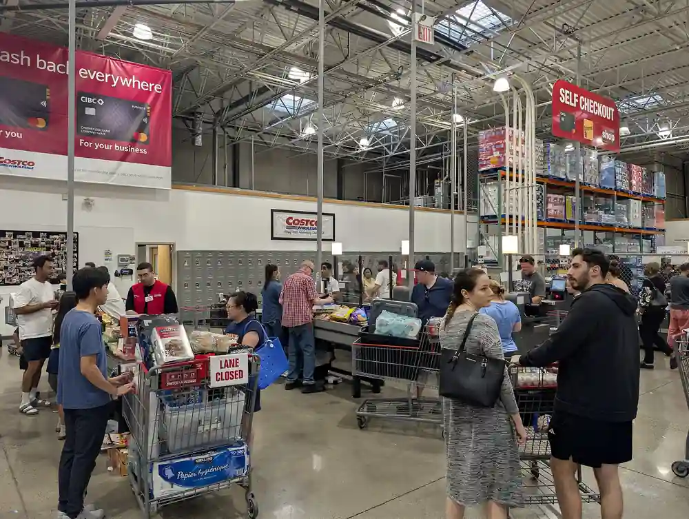 Exterior view of a Costco Wholesale commercial retail warehouse store building with shopping carts and customer parking