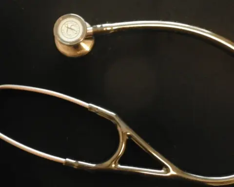 A stethoscope resting on a flat surface, representing employer-sponsored health insurance premiums and out-of-pocket costs
