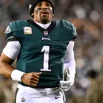 Jalen Hurts in a Philadelphia Eagles uniform holding a football during a game at Lincoln Financial Field.