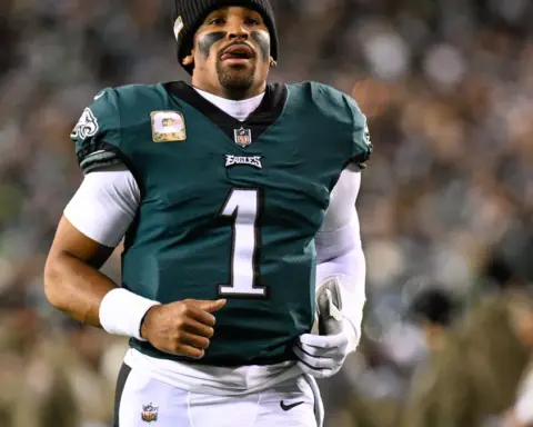 Jalen Hurts in a Philadelphia Eagles uniform holding a football during a game at Lincoln Financial Field.