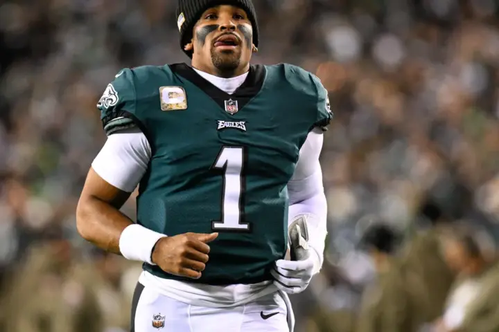 Jalen Hurts in a Philadelphia Eagles uniform holding a football during a game at Lincoln Financial Field.