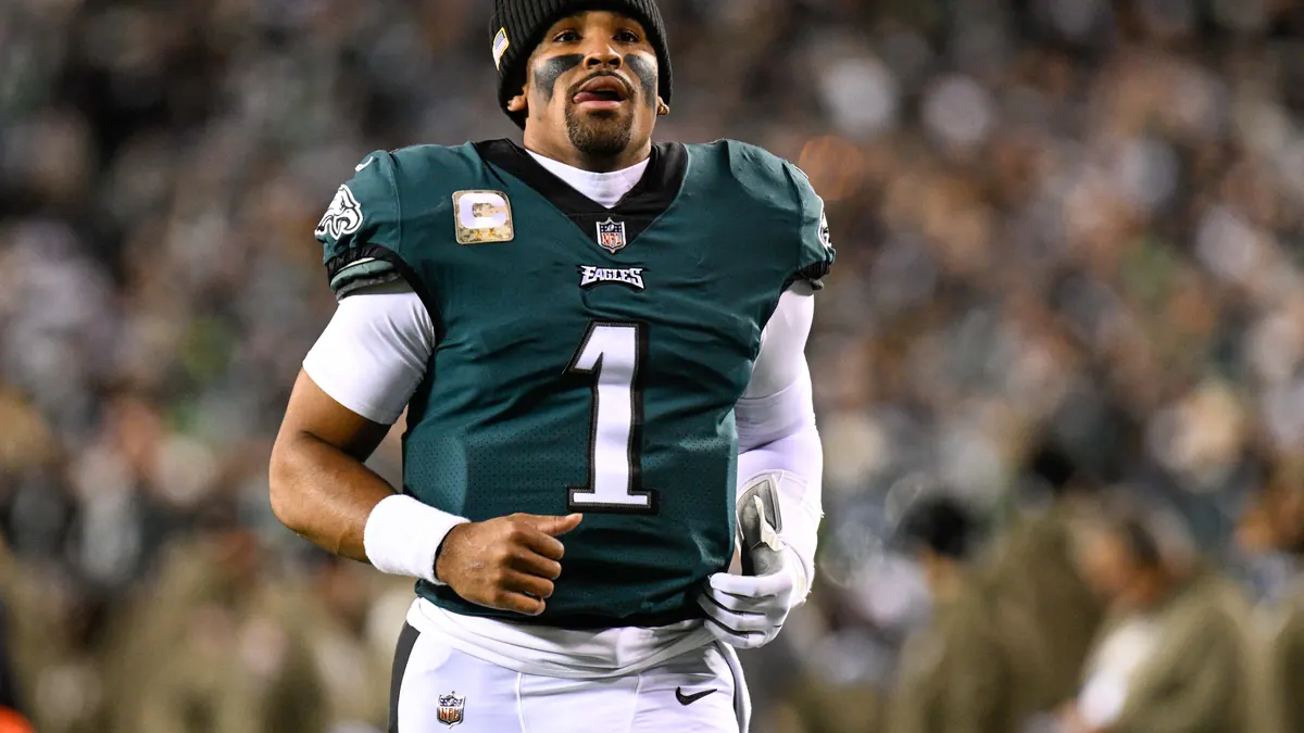 Jalen Hurts in a Philadelphia Eagles uniform holding a football during a game at Lincoln Financial Field.