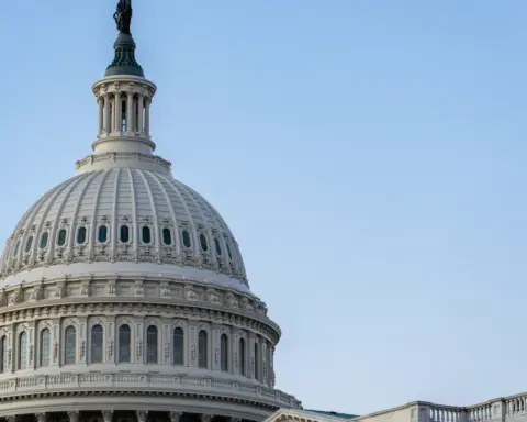 Close view of the white U.S. Capitol dome against a blue sky.