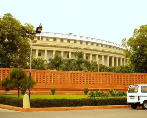 Exterior of India’s circular Parliament building in New Delhi under a blue sky.