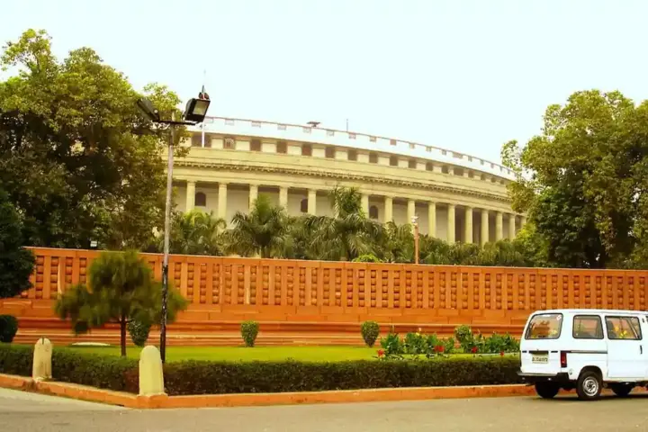 Exterior of India’s circular Parliament building in New Delhi under a blue sky.
